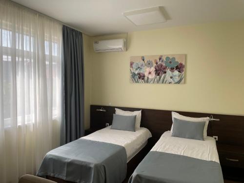 a hotel room with two beds and a window at Santa Villa & restaurant in Sremska Mitrovica