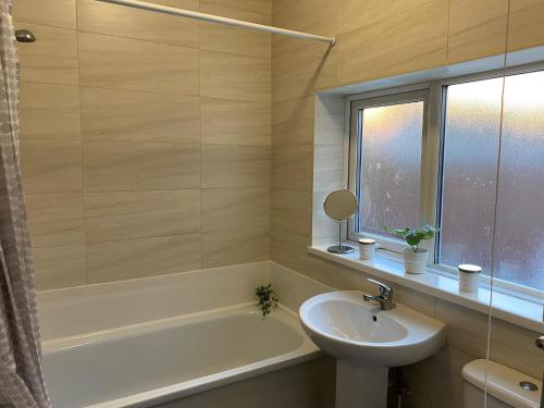 y baño con lavamanos, bañera y lavamanos. en Overhill - Spacious 2 bed ground floor flat close to Newcastle, en Gateshead