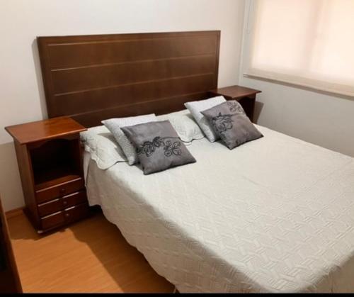 a bedroom with a bed with two pillows on it at Triplex ideal para grupos. Acomoda mais de 20. in Curitiba