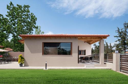 Paralia Sikias的住宿－Athos View - Golden Fig Sykia lodge，一座带绿色草坪的小房子