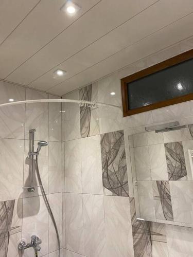 una ducha con puerta de cristal en un baño en Nice apartment, en Pʼonichala