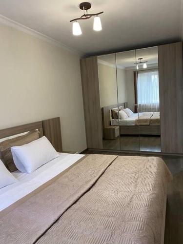 a bedroom with a large bed and a mirror at Nice apartment in Pʼonichala