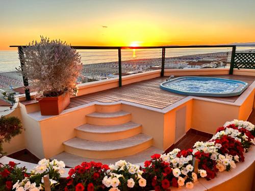 a balcony with a hot tub and flowers at Piccadilly Penthouse with Jacuzzi in Lido di Camaiore