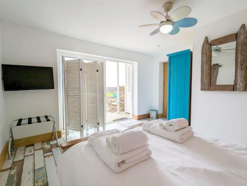 a bedroom with a large white bed with towels on it at Seaside in Selsey