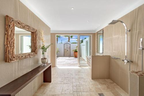 a bathroom with a shower and a mirror and a sink at Villa Ambiance in Marigot