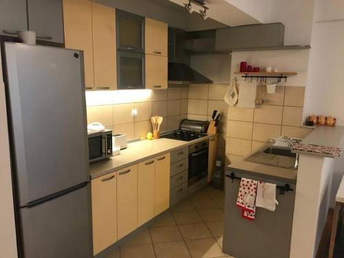 a kitchen with a stainless steel refrigerator and cabinets at First Choice Apartment in Skopje
