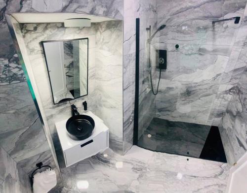La salle de bains est pourvue d'un lavabo noir et d'une douche. dans l'établissement Farmhouse in Virginia County Cavan, à Cavan