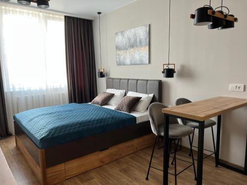 a bedroom with a bed and a wooden table at Apartment Two-room "Family Estate" in Kamianets-Podilskyi