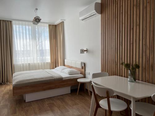 カームヤネツィ・ポジーリシクィイにあるApartment Two-room "Family Estate"のベッドルーム1室(ベッド1台、テーブル、テーブル、椅子付)
