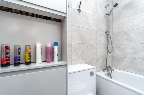 a bathroom with a shower and a toilet and a sink at Modern Apartment in East London in London