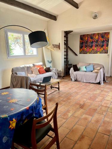 un salon avec une table et un canapé dans l'établissement Villa 5 pièces Sanary - 12 min à pied plage Bandol Lido - 350 m carres jardin - Climatisation - Vue Montagne du Gros cerveau - la pinède, à Sanary-sur-Mer