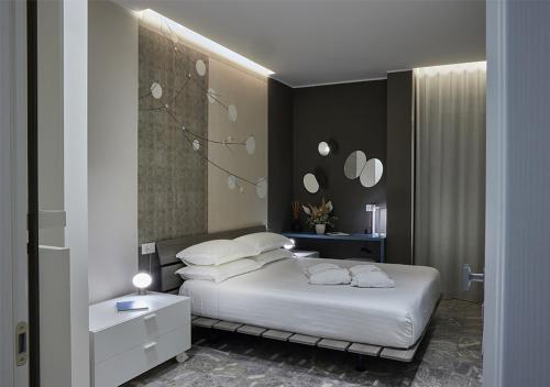 a bedroom with a bed with white sheets and pillows at IDILLIO YOUR LUXURY ROOMS in Pescara