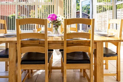 a wooden table with chairs and a vase of flowers at Fair View - Off Street Parking and Garden in Shrewsbury