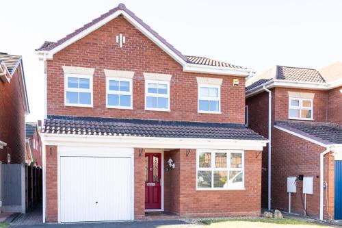 a red brick house with a white garage at Fair View - Off Street Parking and Garden in Shrewsbury