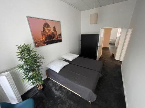 ベルリンにあるBerlinhome Apartment Köpenickのベッドルーム1室(ベッド1台、植物付)