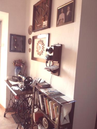 a room with a book shelf with books and pictures on the wall at Belli come il Sole in Serri