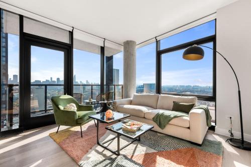 a living room with a couch and chairs and large windows at Avra Stylish Apartments Prime West Loop Location Near Union Park in Chicago