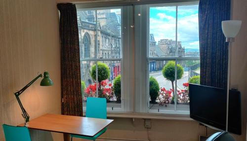 a desk in front of a window with a view of a city at Royal Mile Apartment, 1 minute from the castle. in Edinburgh