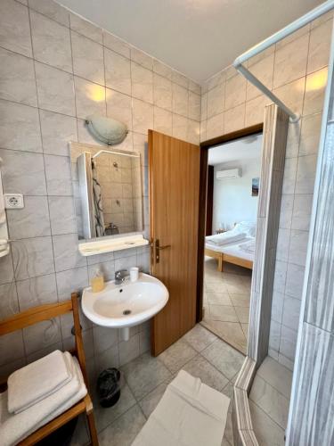 a bathroom with a sink and a shower at Rooms & Apartment Hegic with parking in Zadar