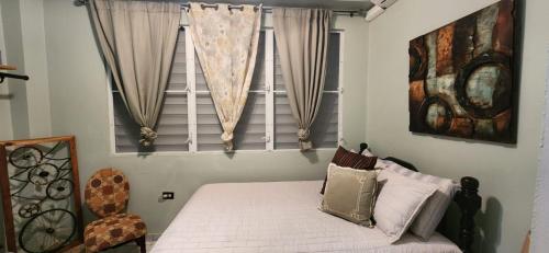 a bedroom with a bed in front of a window at Casa Campo y mis Memorias-2ND LEVEL-with pool in Hormigueros