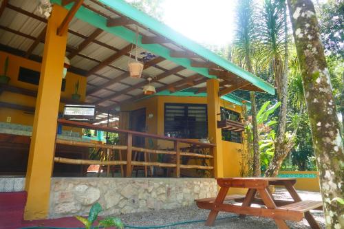 a yellow house with a bench in front of it at RiverHill Hideaway in Monkey Fall