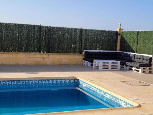 un patio trasero con piscina y valla en Belvilla by OYO Villa Valerya, en Ibáñez