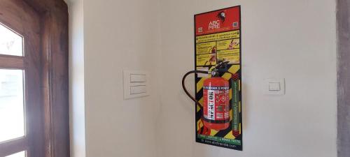 a poster of a fire extinguisher hanging on a wall at Anya Paradise in Ooty