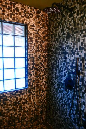 a bathroom with a window and a tiled wall at RiverHill Hideaway in Monkey Fall
