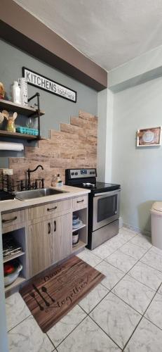 a kitchen with a sink and a stove at Casa Campo y mis Memorias-2ND LEVEL-with pool in Hormigueros