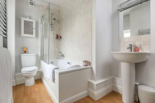 a white bathroom with a toilet and a sink at No 2 The Old School House, Winchester in Winchester