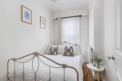 a white bedroom with a bed and a window at No 2 The Old School House, Winchester in Winchester