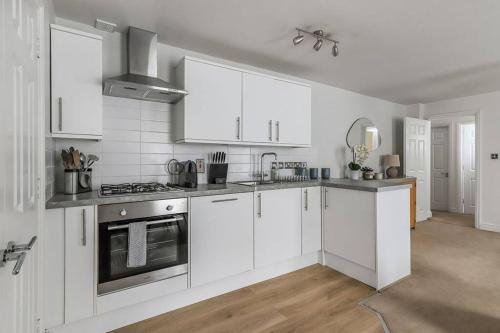 a kitchen with white cabinets and a stove top oven at No 2 The Old School House, Winchester in Winchester