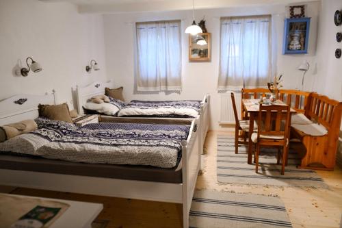 two beds in a room with a table and a dining room at Ubytovanie na dedine in Veľká Chocholná