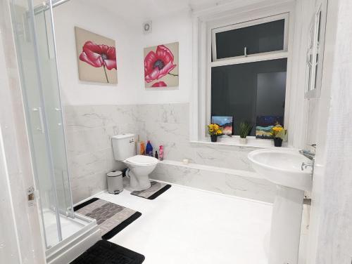 a white bathroom with a toilet and a sink at Charming 4-Bedroom House in Dover in Dover