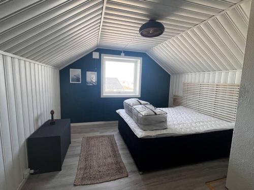 1 dormitorio con 1 cama en una habitación con paredes azules en Storgata 5 en Berlevåg