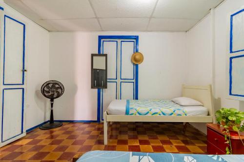 um quarto com uma cama e uma ventoinha em THE MANGO TREE HOSTEL 4:20 em Cartagena das Índias