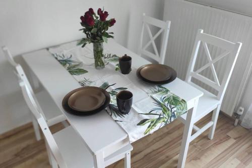 a white table with two hats and flowers on it at Appartement am Wörthersee in Selpritsch