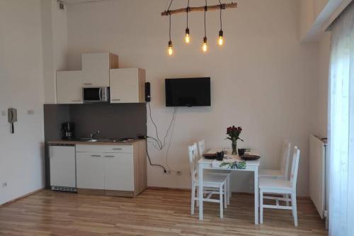 una cucina e una sala da pranzo con tavolo e sedie di Appartement am Wörthersee a Selpritsch