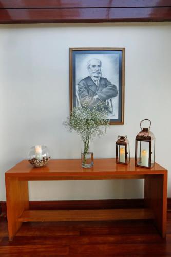 a table with a picture of a man on the wall at Gran Hotel Vicente Costanera in Puerto Montt