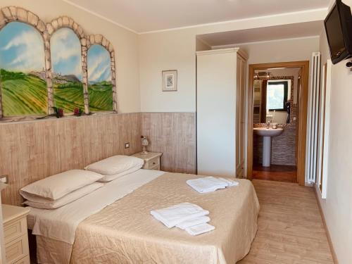 a bedroom with a bed with two towels on it at b&b DOREMI in Osimo