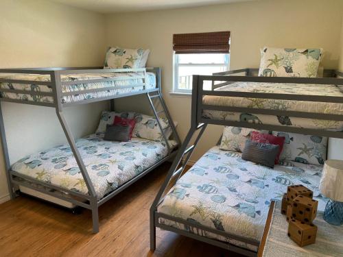 una stanza con tre letti a castello e una finestra di Sunshine DayDream by SurfBreakLLC a Surfside Beach