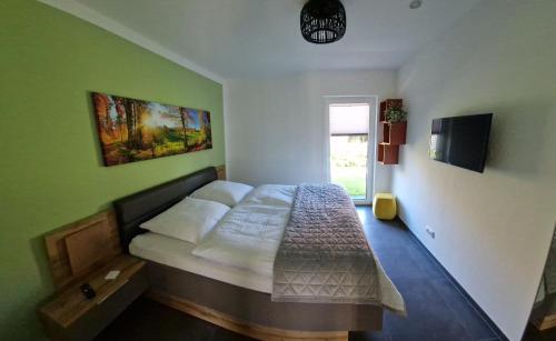 um quarto com uma cama numa parede verde em Lieblingsort am Moor em Gnarrenburg