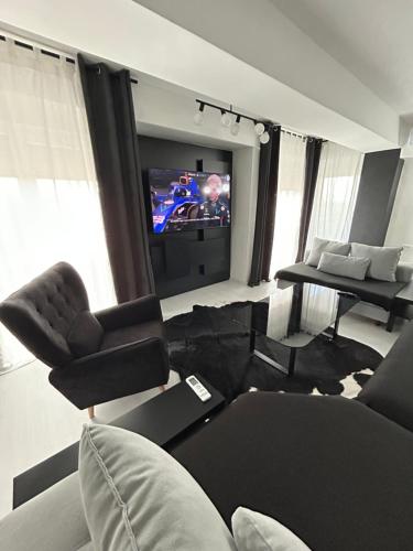 a living room with a couch and a television at Sandev apartments Black&White in Štip