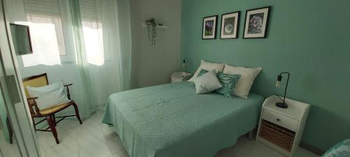 een slaapkamer met een groen bed en een stoel bij Ofelia Terrace House in Portimão