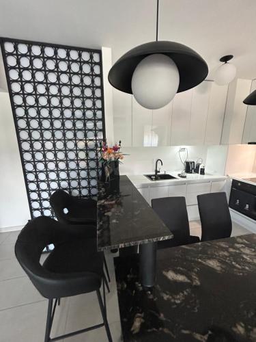 een keuken met een zwarte tafel en zwarte stoelen bij Sandev apartments Black&White in Štip