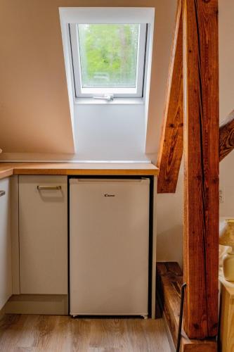 a kitchen with a small refrigerator under a window at Apartmán Pod Zámkem in Moravský Krumlov