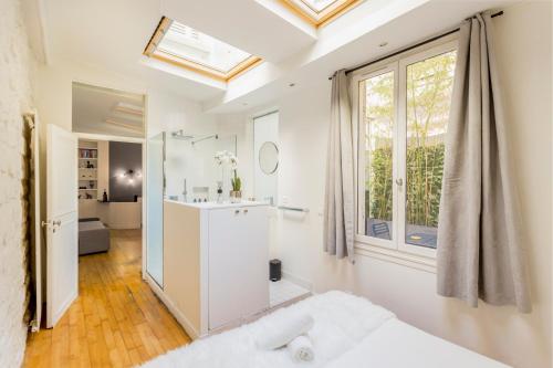 uma casa de banho branca com um lavatório e uma janela em SLEEPOO - Fabulous 8 em Paris