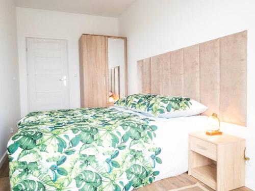 sypialnia z łóżkiem z narzutą z zielonego liścia w obiekcie Semafor w Olsztynie