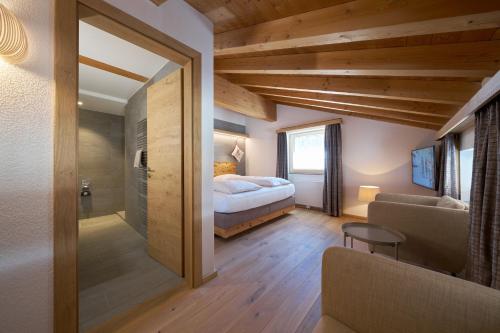 a bedroom with a bed and a couch in a room at Aparthotel Grischuna in Samnaun