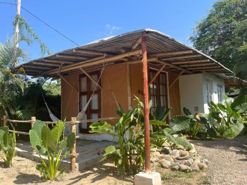 a small house with a wooden roof at KUA Cabañas in Palomino